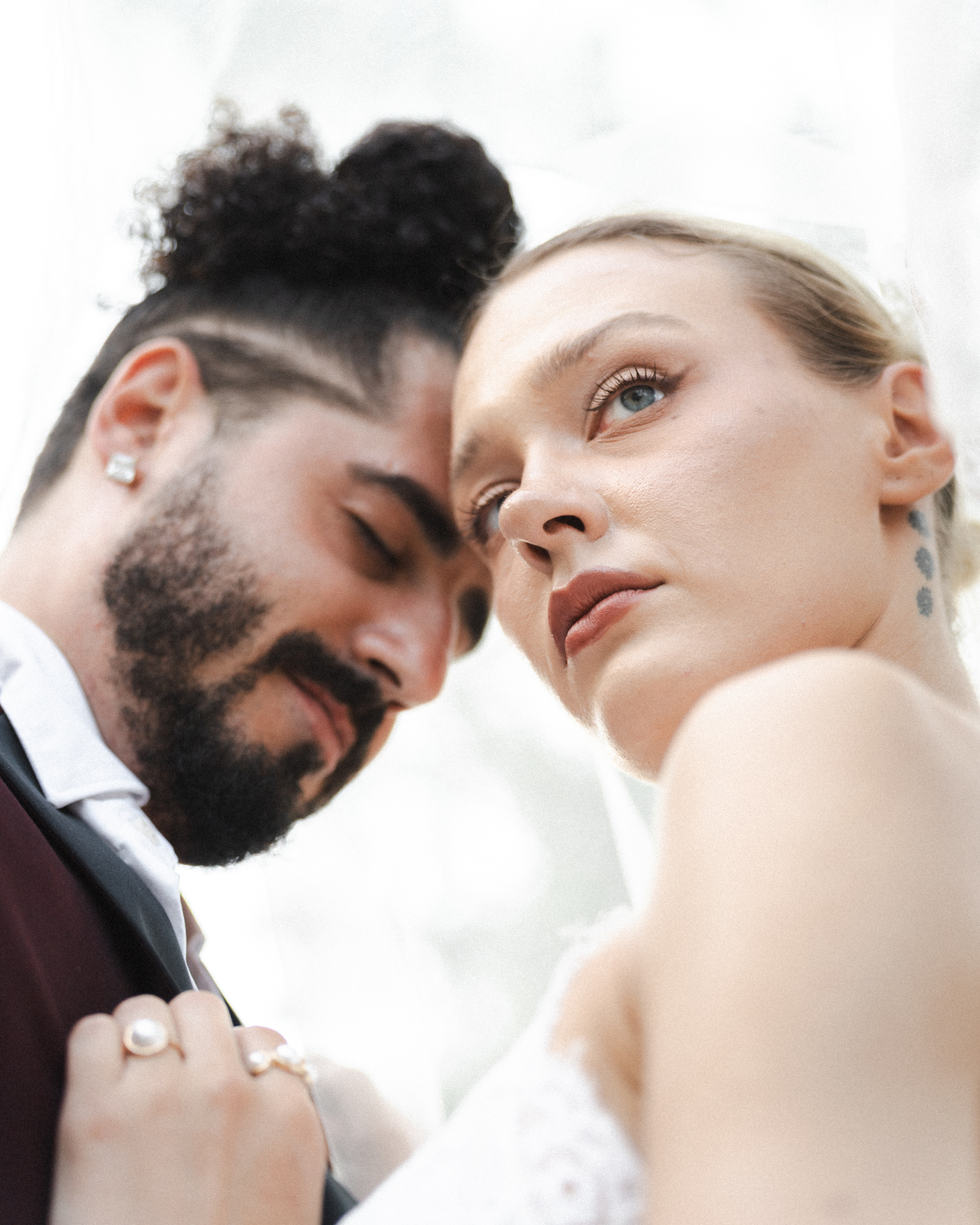 Intimate close-up of a bride and groom under a veil